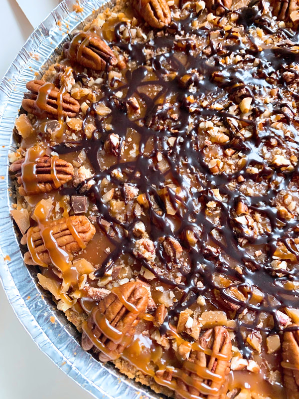 CHEESECAKE MENU: Our turtle cheesecake topped with drizzles of salted caramel sauce and chocolate ganache, chopped pecans and toffee, with whole pecans around the circumference.