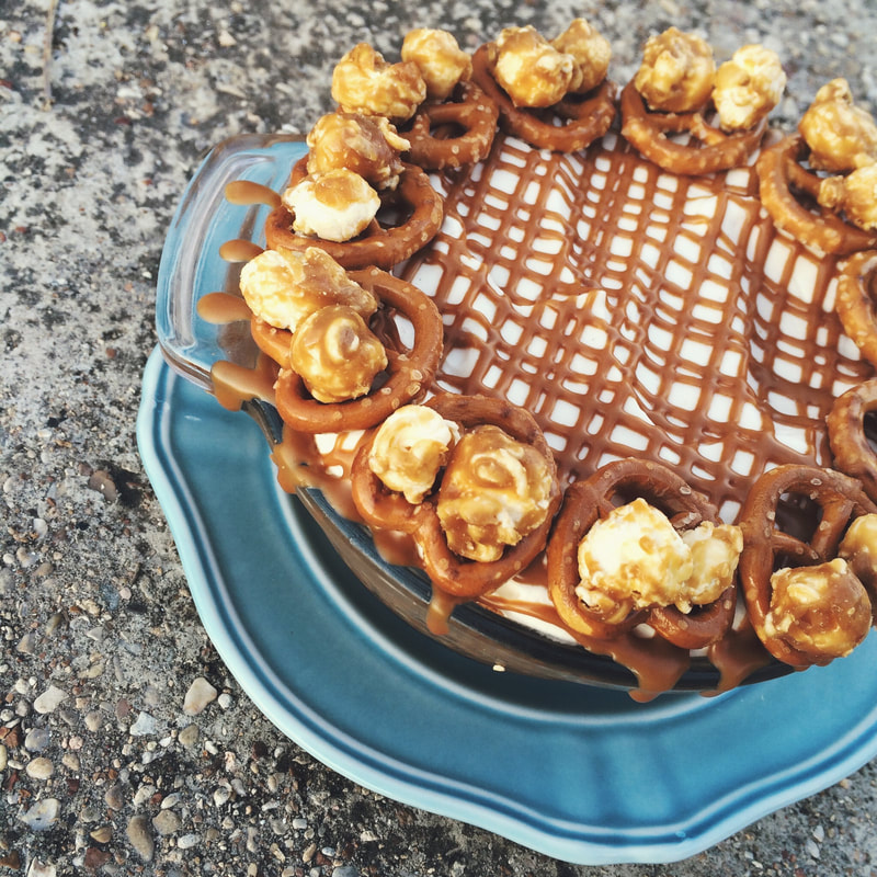 PIES MENU: Pictured is our Cookie Butter Cream Pie which has a pretzel and caramel corn crust filled with Lotus cookie butter pudding and topped with spiced vanilla whipped cream. Drizzled with cookie butter in a criss cross pattern. Pretzels and caramel corn balls line the circumference of the pie. 